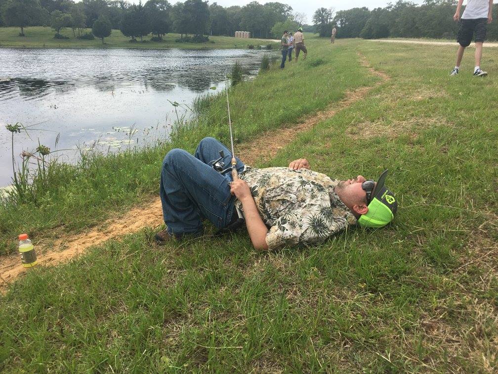 young man resting beside lake